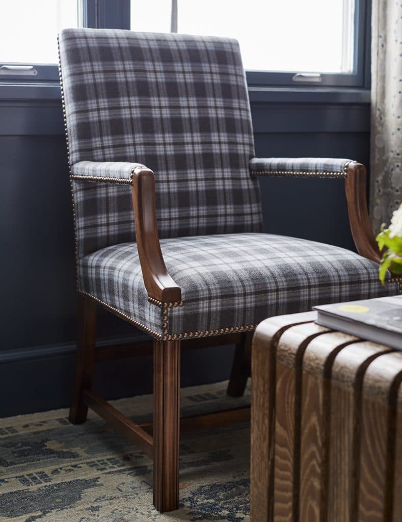 A recovered armchair in a plaid wool, reupholstered in our workrooms