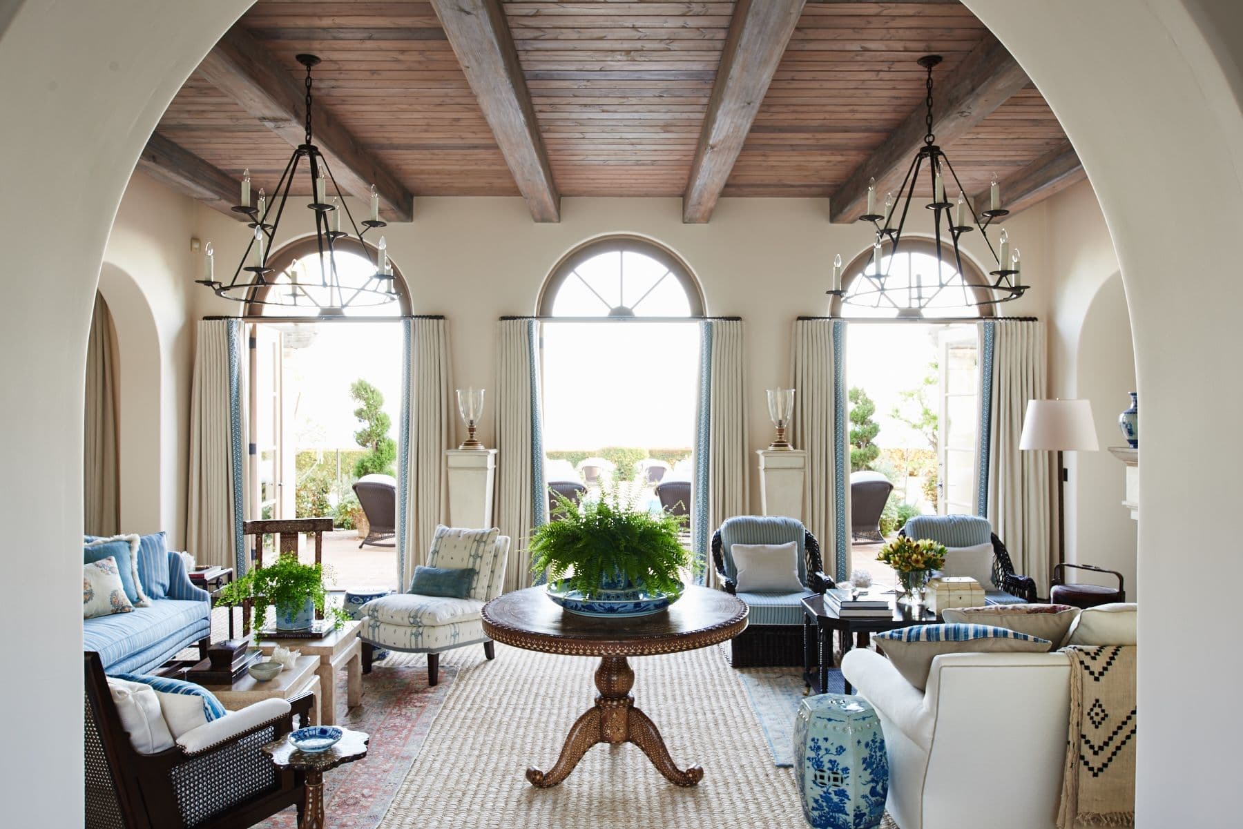 Arched living room with exposed wood ceiling, drapery with custom trim edge and upholstered furniture